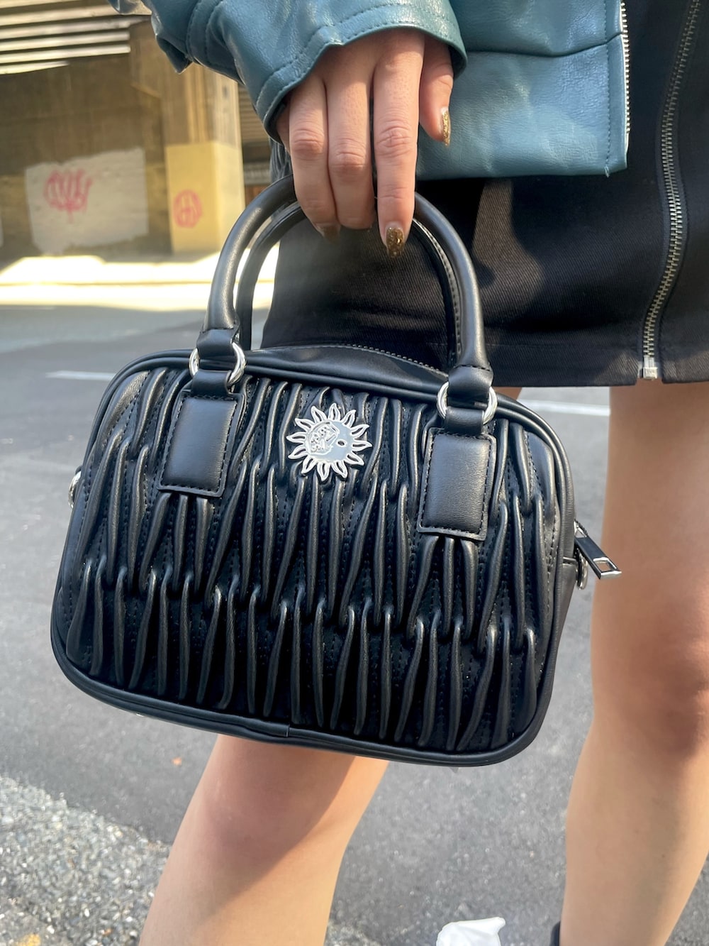 ホワイト系のショルダーバッグ、ブラック系のスカート、ブラック系のTシャツ/カットソーを着用したレディースの秋コーディネートの8枚目の写真