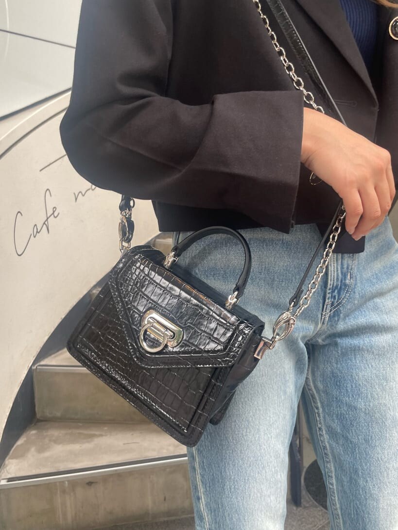 ブラック系のブーツ、ブラック系のテーラードジャケット、ブラック系のハンドバッグを着用したレディースの秋コーディネートの6枚目の写真