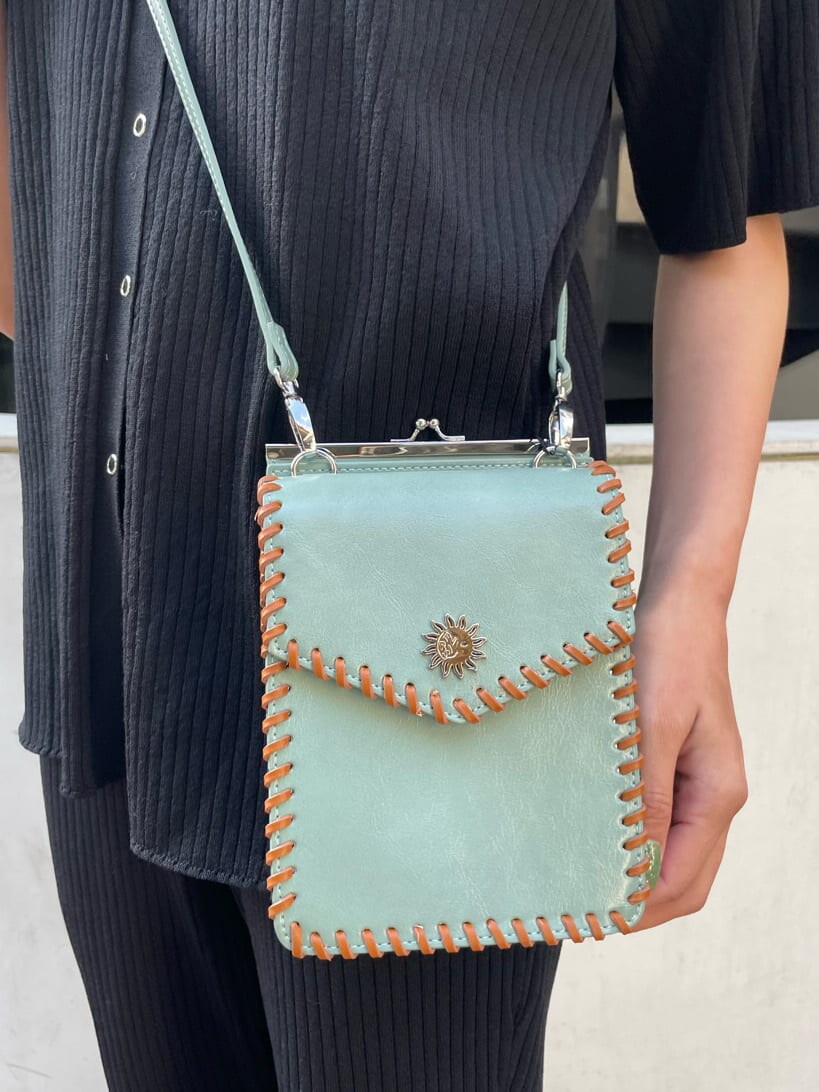 ブラック系のパンプス、グリーン系のショルダーバッグ、ブラック系のその他パンツを着用したレディースの春コーディネートの5枚目の写真