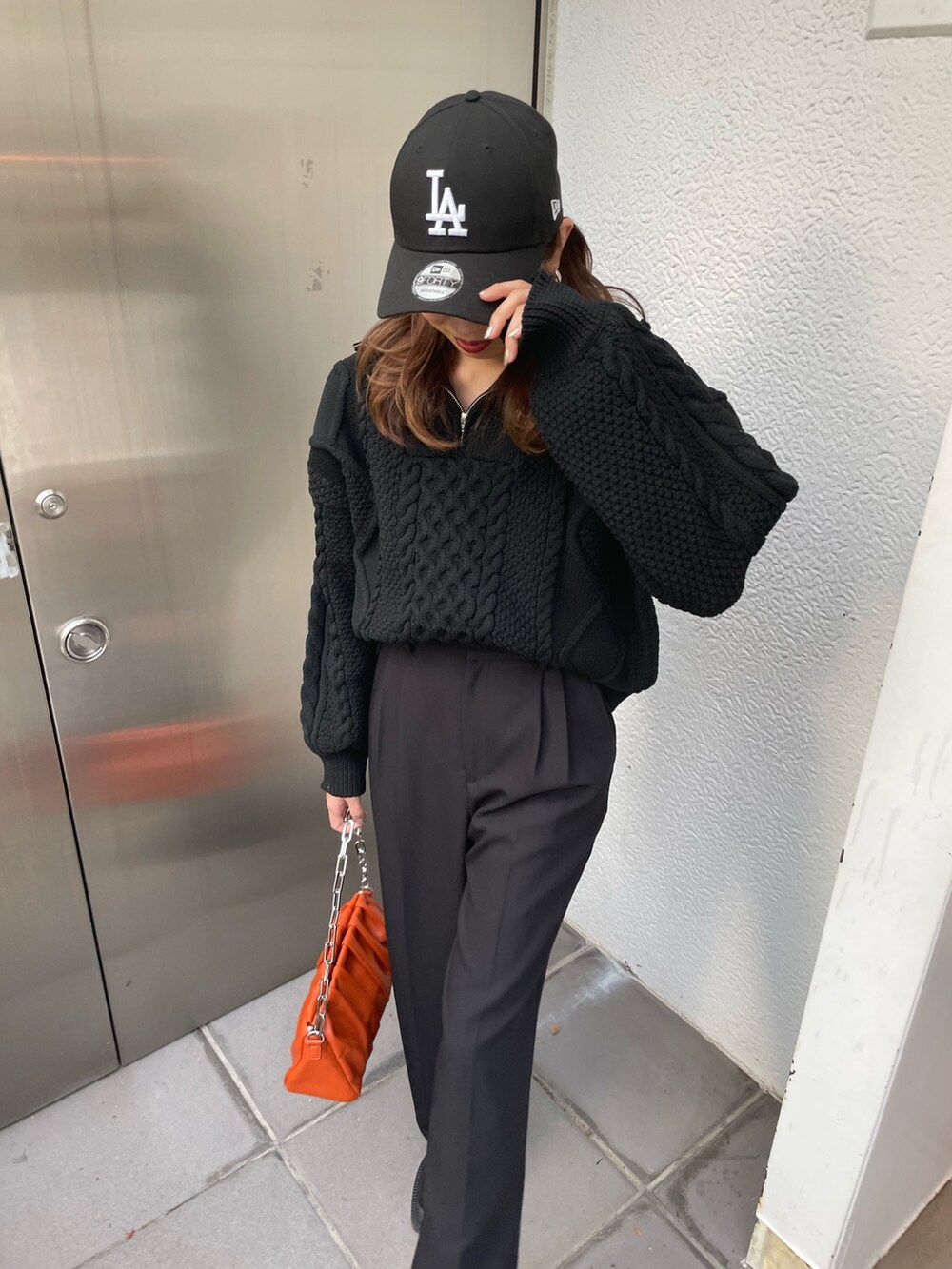 ブラック系のニット/セーター、ブラック系のスラックス、ブラック系のブーツを着用したレディースの冬コーディネートの6枚目の写真