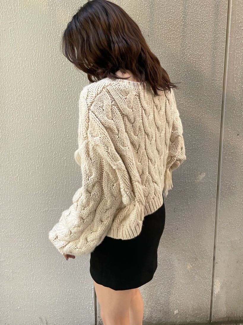 ベージュ系のブーツ、ホワイト系のニット/セーター、ブラック系のスカートを着用したレディースの秋コーディネートの5枚目の写真