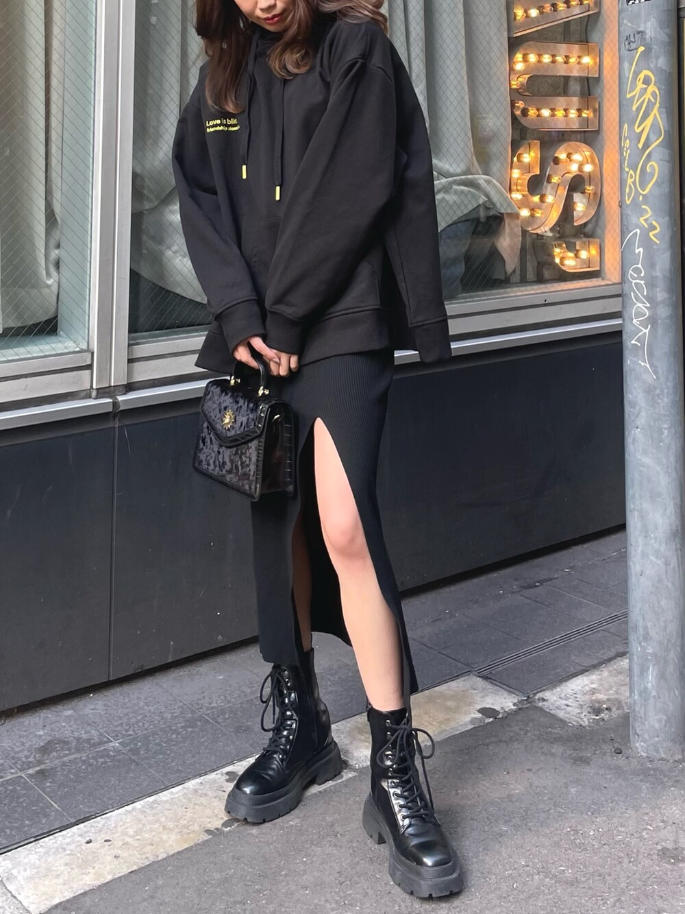 ブラック系のパーカー、ブラック系のショルダーバッグ、ブラック系のワンピースを着用したレディースの冬コーディネートの4枚目の写真