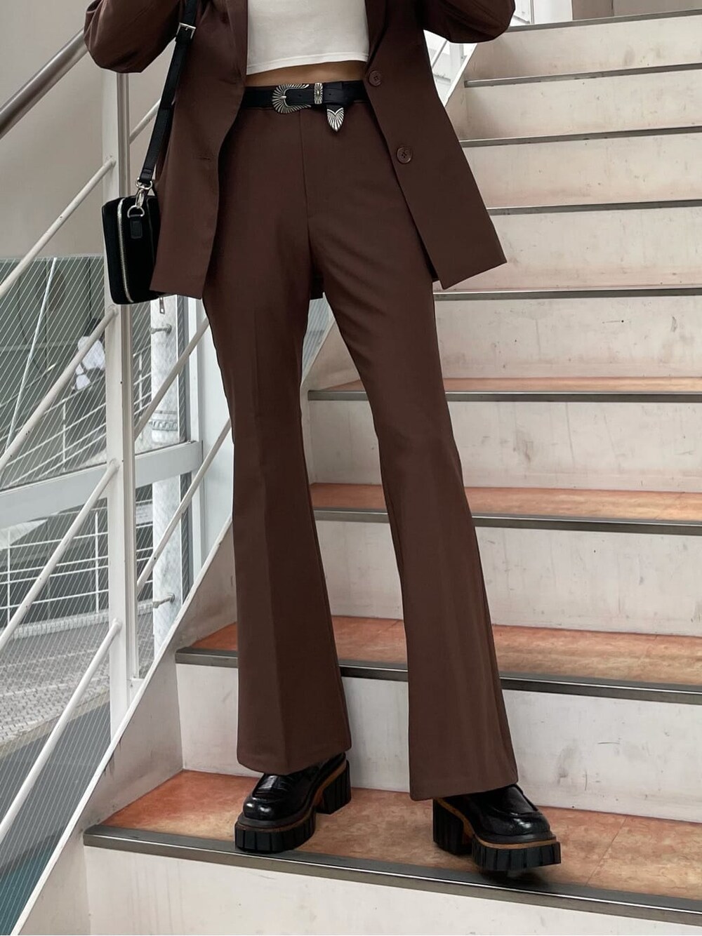 ブラック系のローファー、ブラック系のハンドバッグ、ホワイト系のTシャツ/カットソーを着用したレディースの夏コーディネートの4枚目の写真