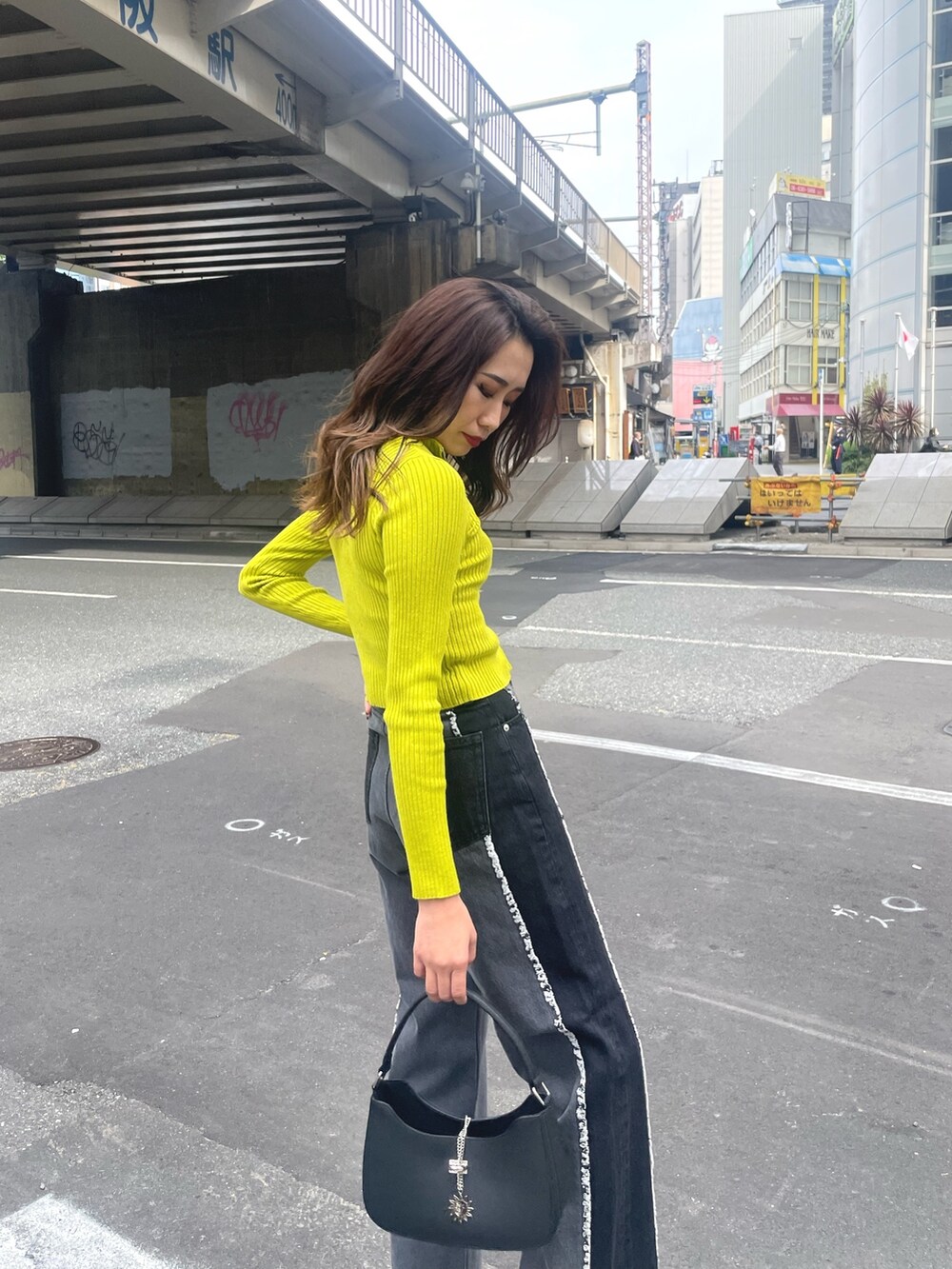 ブラック系のブーツ、ブラック系のハンドバッグ、ブラック系のニット/セーターを着用したレディースの秋コーディネートの4枚目の写真