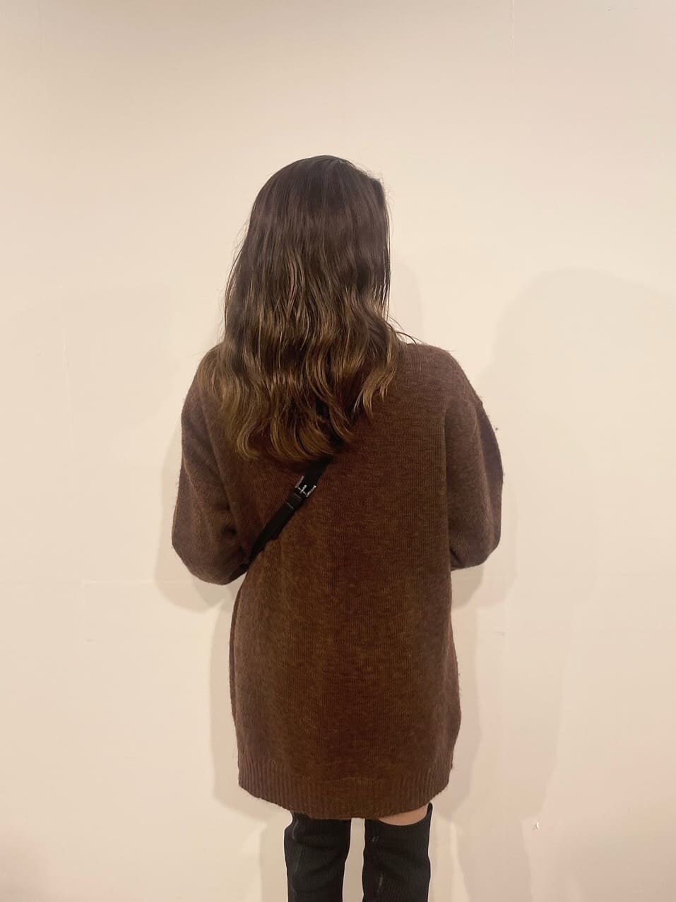 ブラウン系のワンピース、ブラック系のブーツ、ブラック系のショルダーバッグを着用したレディースの秋コーディネートの4枚目の写真