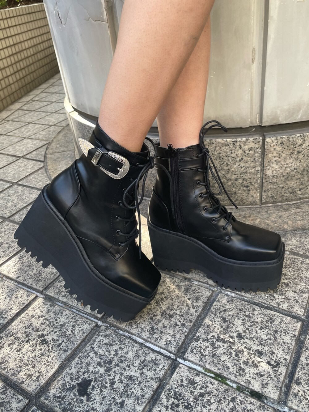 グレー系のスウェット、ブラック系のショルダーバッグ、ブラック系のブーツを着用したレディースの冬コーディネートの8枚目の写真