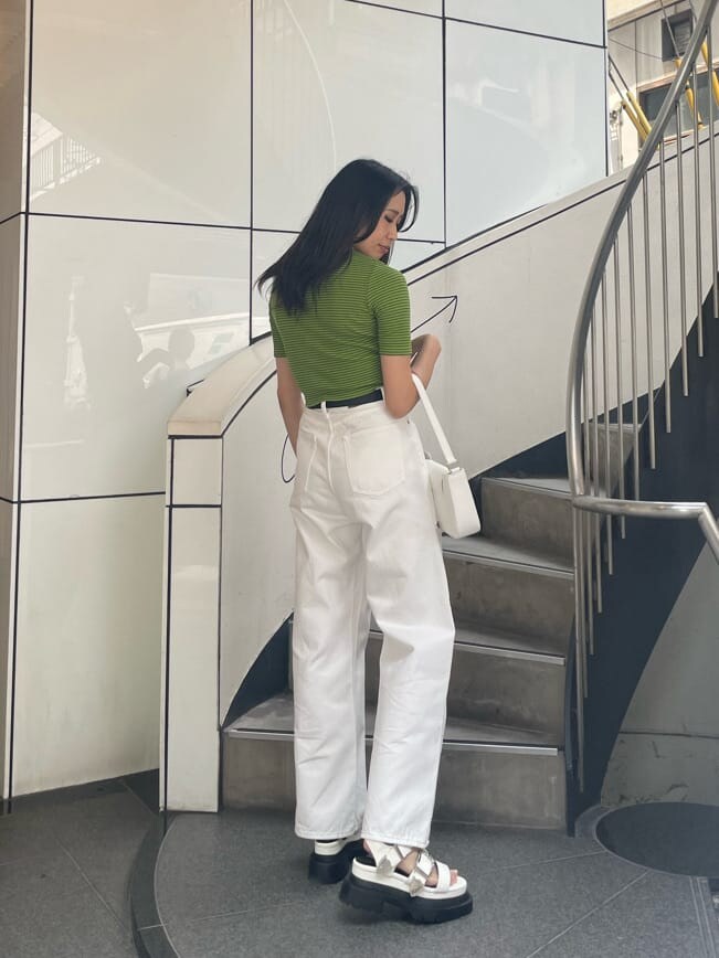 グリーン系のTシャツ/カットソー、ホワイト系のショルダーバッグ、ホワイト系のデニムパンツを着用したレディースの春コーディネートの2枚目の写真