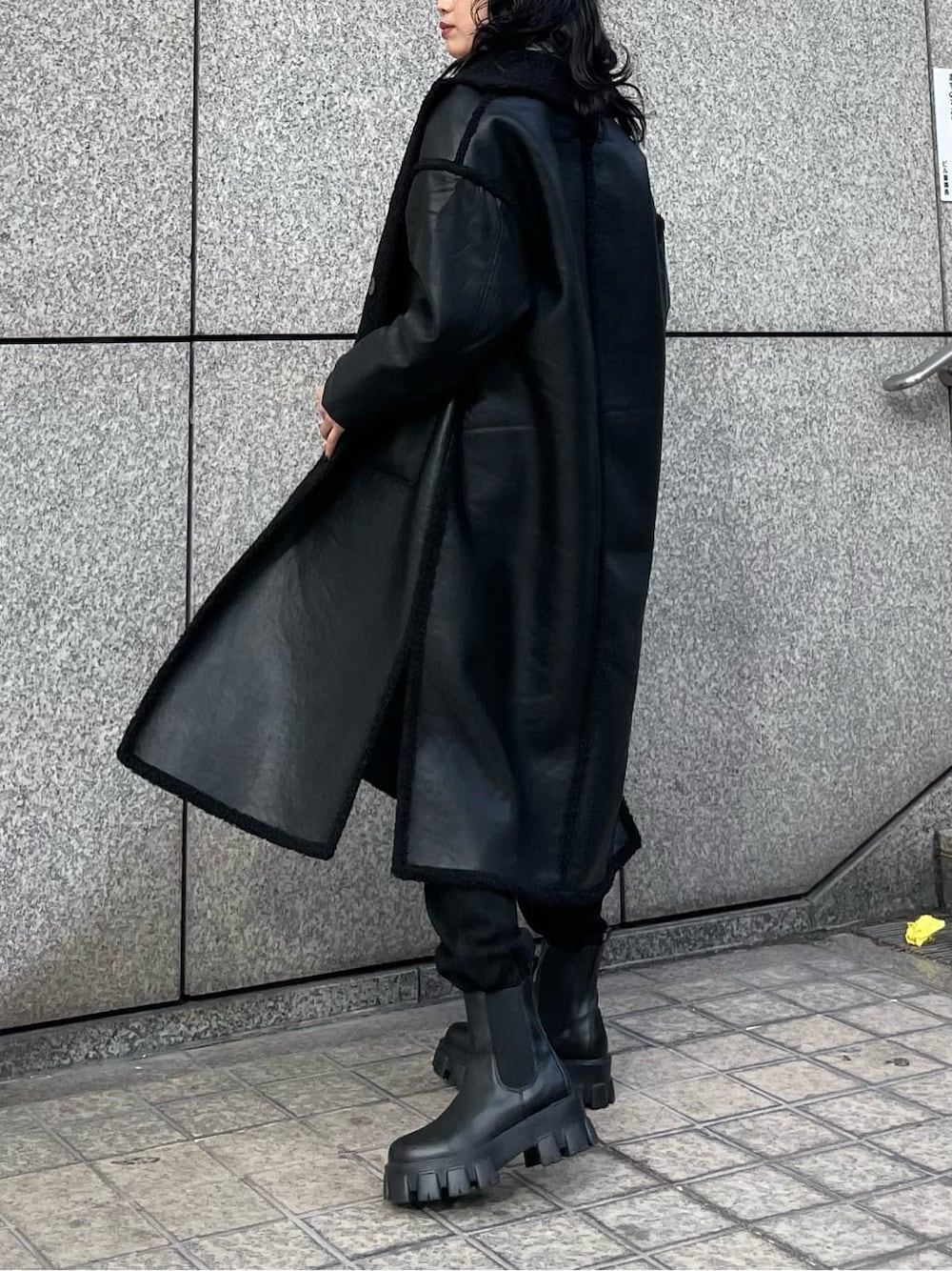 ブラック系のブーツ、ホワイト系のスウェット、ブラック系のその他アウターを着用したレディースの冬コーディネートの2枚目の写真