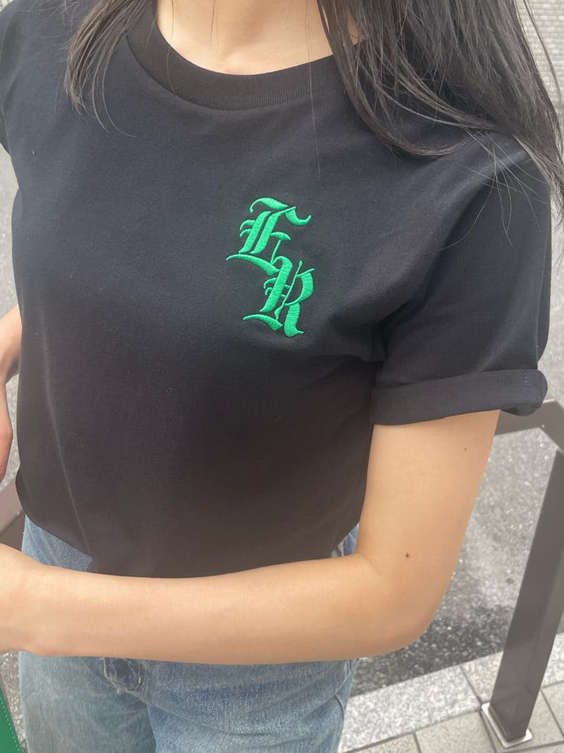 グリーン系のショルダーバッグ、ブルー系のデニムパンツ、ブラック系のスニーカーを着用したレディースの夏コーディネートの5枚目の写真