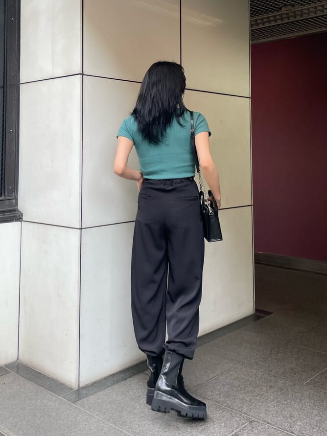 ブラック系のその他パンツ、グリーン系のTシャツ/カットソー、ブラック系のブーツを着用したレディースの春コーディネートの2枚目の写真