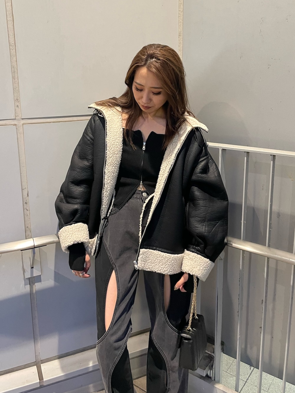 ブラック系のニット/セーター、ブラック系のデニムパンツ、ブラック系のブーツを着用したレディースの夏コーディネートの3枚目の写真