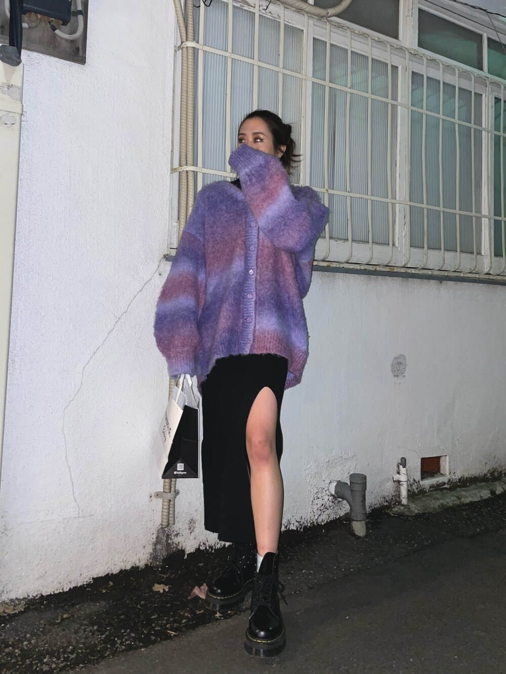 パープル系のカーディガン/ボレロ、ブラック系のワンピース、ブラック系のブーツを着用したレディースの冬コーディネートの2枚目の写真