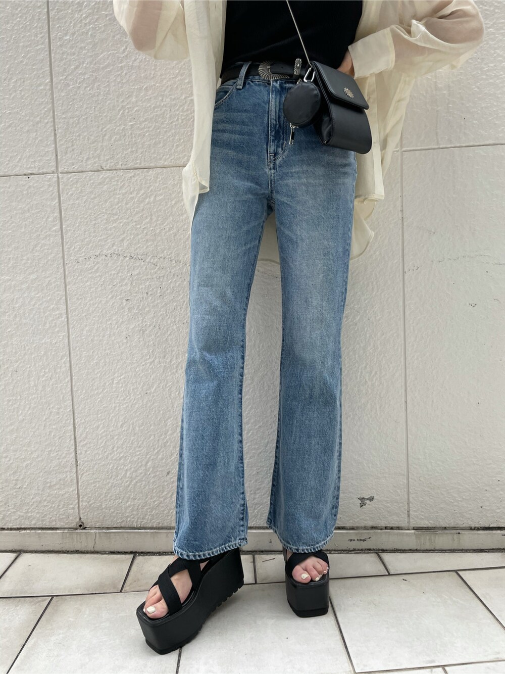 ホワイト系のシャツ/ブラウス、ブラック系のサンダル、ブルー系のデニムパンツを着用したレディースの夏コーディネートの7枚目の写真