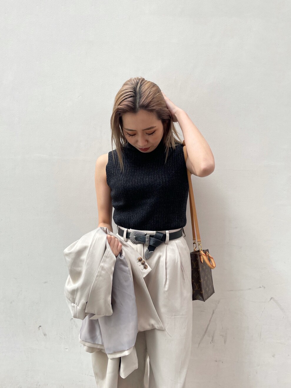 グレー系のテーラードジャケット、ブラック系のパンプス、ブラック系のタンクトップを着用したレディースの春コーディネートの3枚目の写真