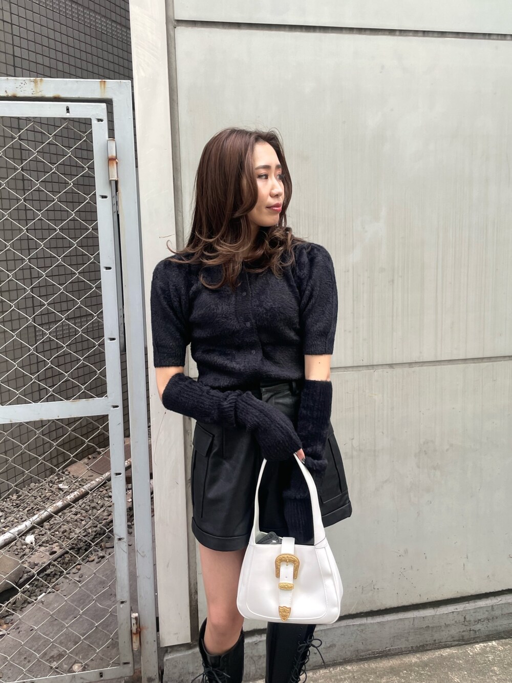 ブラック系のニット/セーター、ブラック系のその他パンツ、ホワイト系のハンドバッグを着用したレディースの冬コーディネートの4枚目の写真