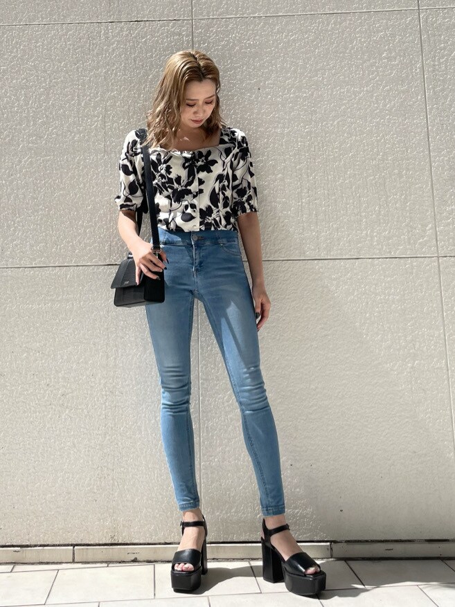 ブラック系のショルダーバッグ、ブルー系のデニムパンツ、ホワイト系のシャツ/ブラウスを着用したレディースの春コーディネートの2枚目の写真