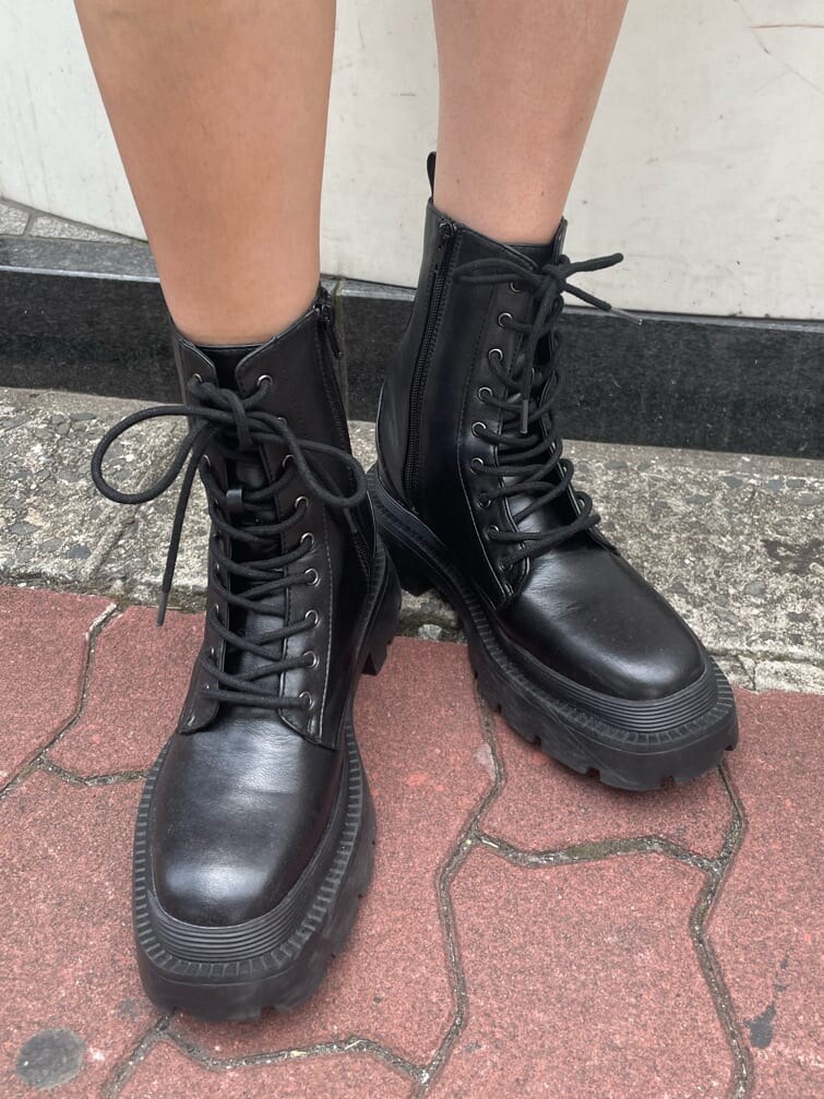 ブラック系のブーツ、ブラック系のワンピース、パープル系のショルダーバッグを着用したレディースの春コーディネートの9枚目の写真