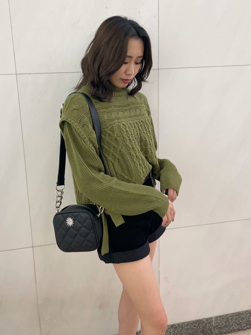 ベージュ系のニット/セーター、ブラック系のブーツ、ブラック系のショルダーバッグを着用したレディースの秋コーディネートの2枚目の写真