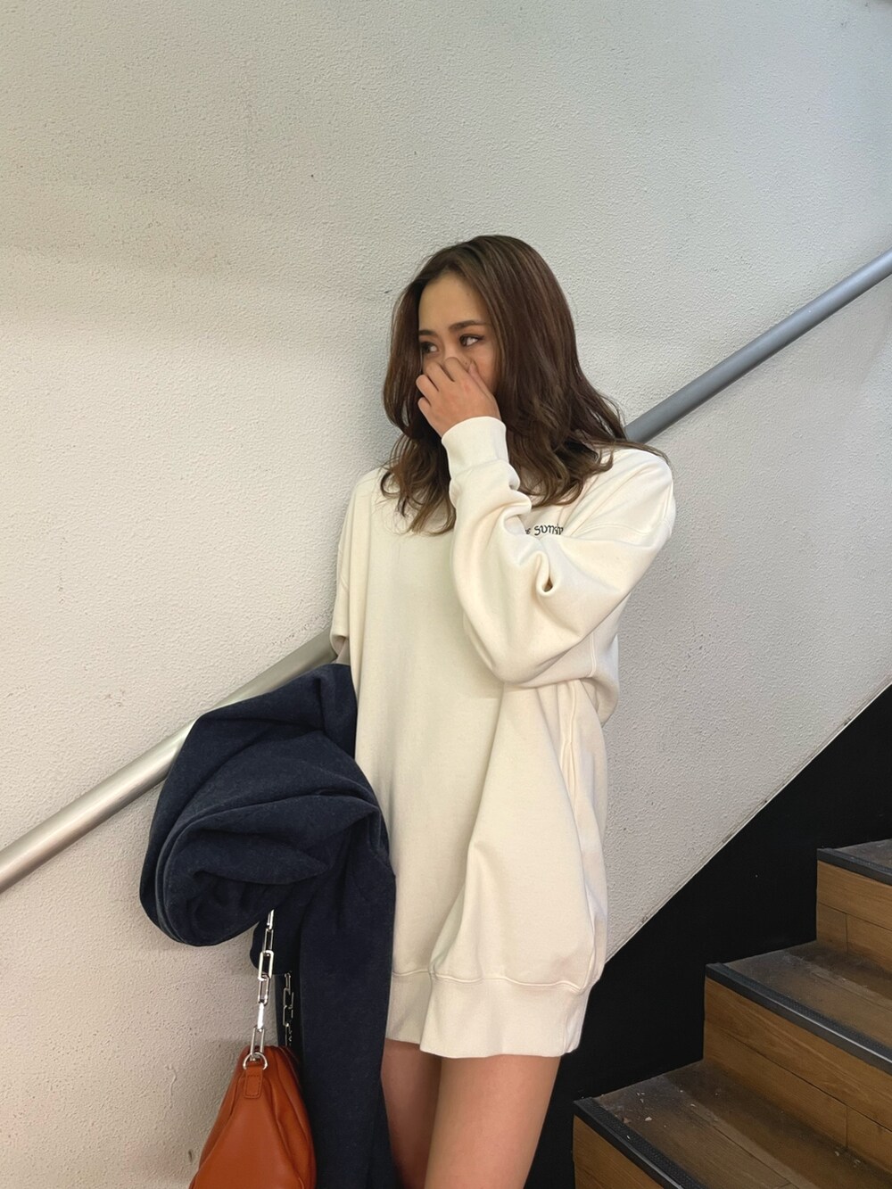 ブラック系のブーツ、ホワイト系のスウェット、ブルー系のその他アウターを着用したレディースの冬コーディネートの4枚目の写真