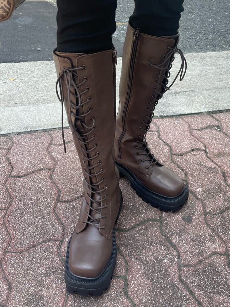 ブラウン系のブーツ、ブラウン系のボストンバッグ、ホワイト系のシャツ/ブラウスを着用したレディースの秋コーディネートの9枚目の写真