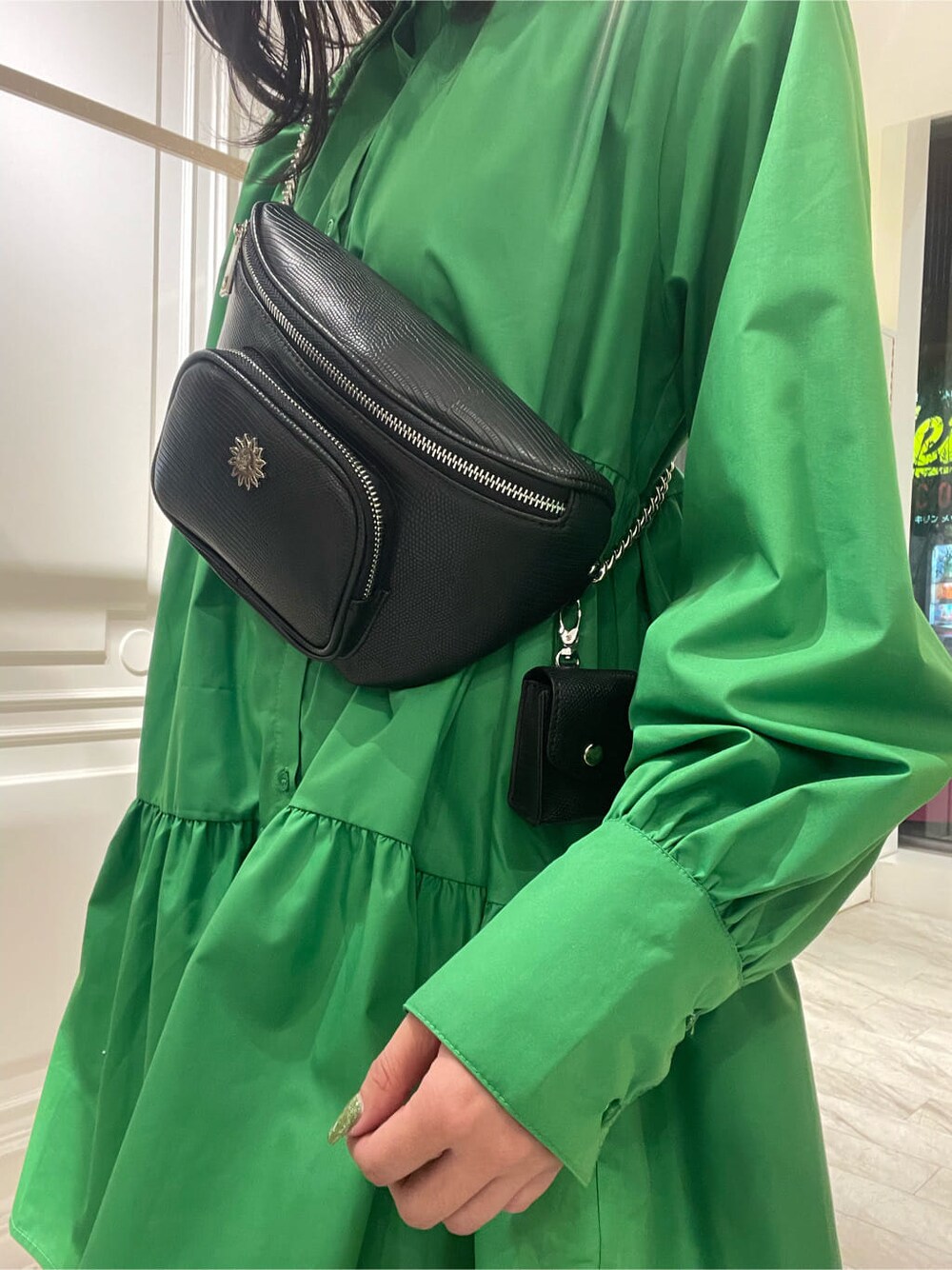 ブラック系のブーツ、グリーン系のシャツワンピース、ブラック系のボディバッグ/ウエストポーチを着用したレディースの冬コーディネートの5枚目の写真