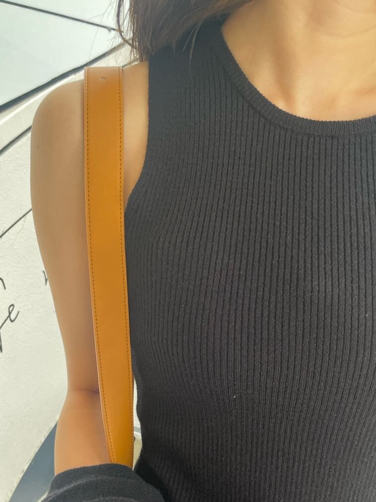 ブラック系のワンピース、ブラック系のブーツ、イエロー系のショルダーバッグを着用したレディースの秋コーディネートの9枚目の写真