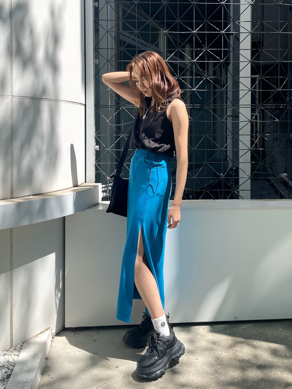 ブラック系のタンクトップ、ブラック系のスニーカーを着用したレディースの春コーディネートの3枚目の写真