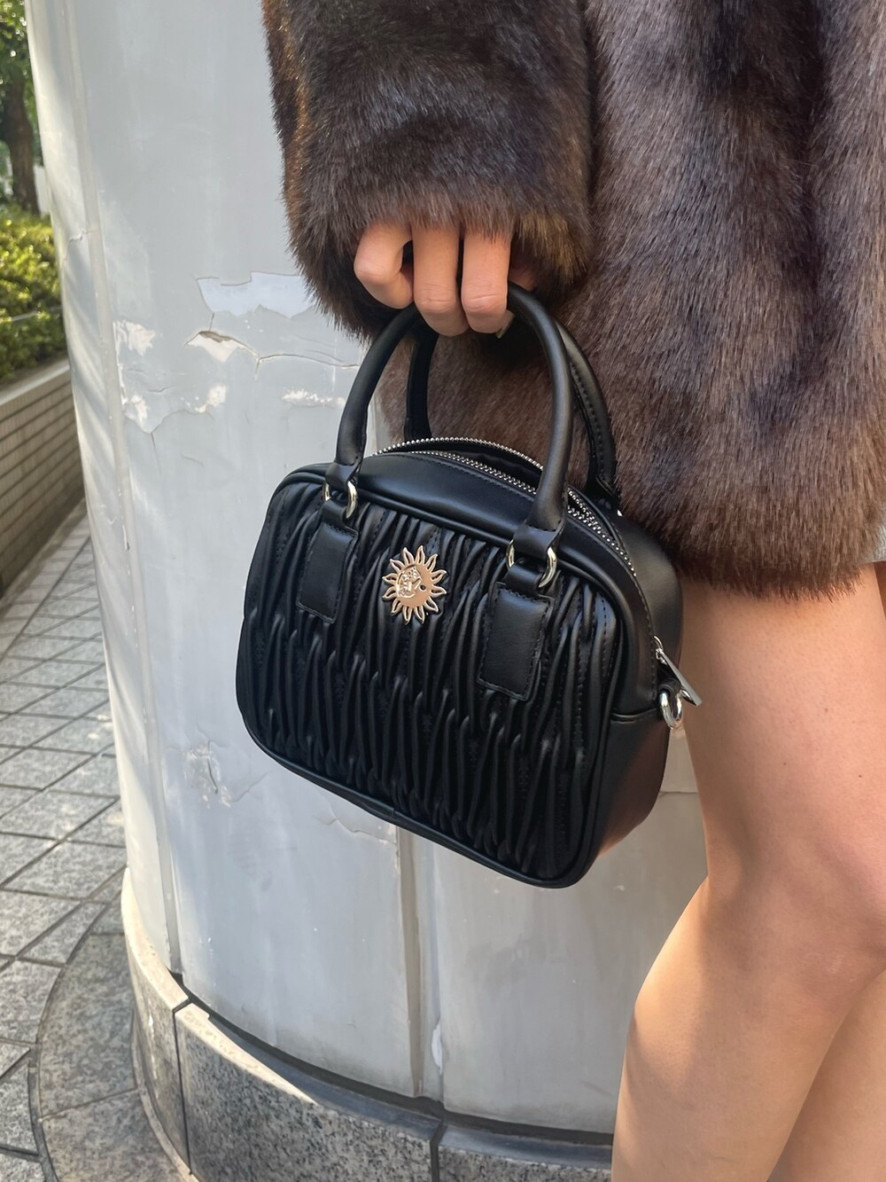 グレー系のスウェット、ブラック系のショルダーバッグ、ブラック系のブーツを着用したレディースの冬コーディネートの6枚目の写真