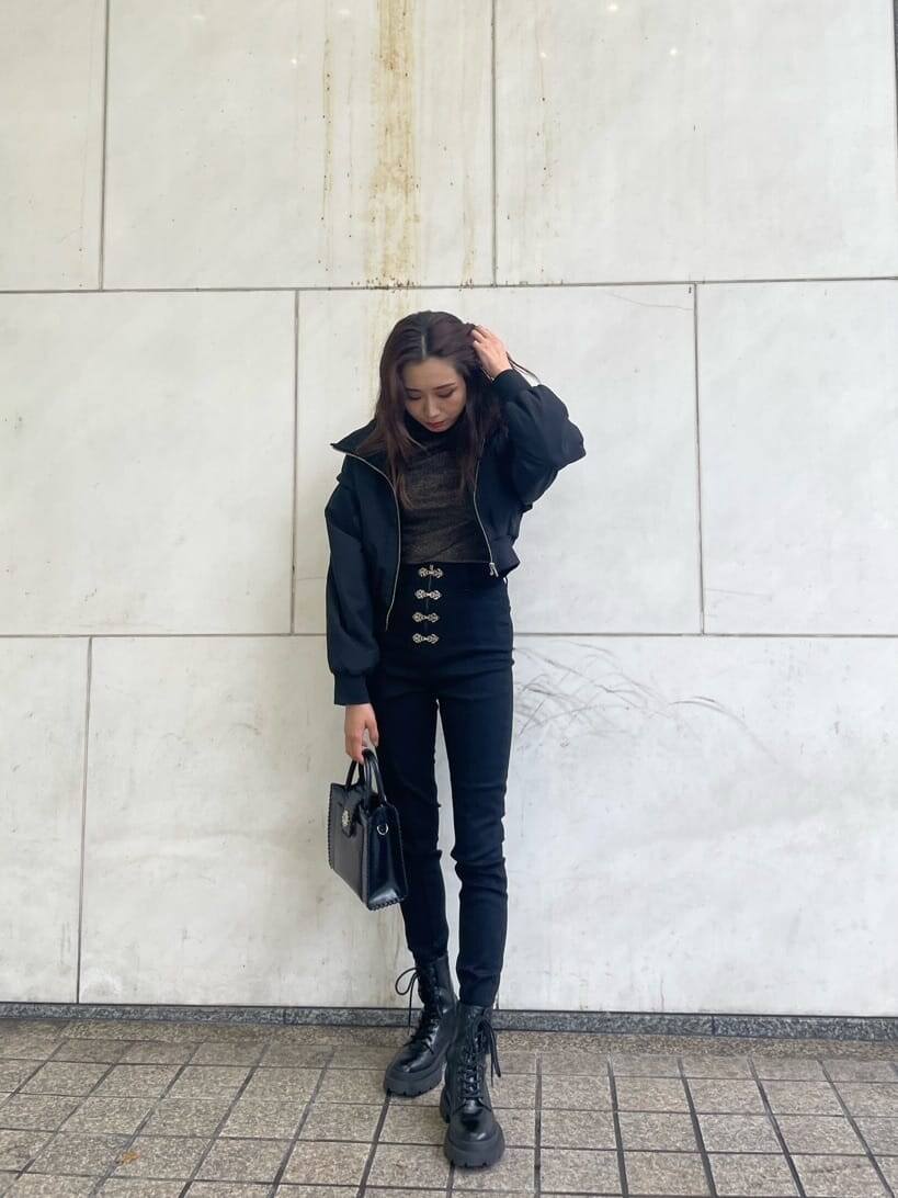 ブラック系のブーツ、ブラック系のデニムパンツ、ブラック系のショルダーバッグを着用したレディースの秋コーディネートの3枚目の写真
