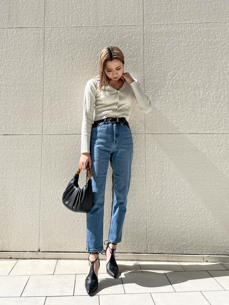 ブラック系のパンプス、ブルー系のデニムパンツ、ブラック系のハンドバッグを着用したレディースの春コーディネートの2枚目の写真