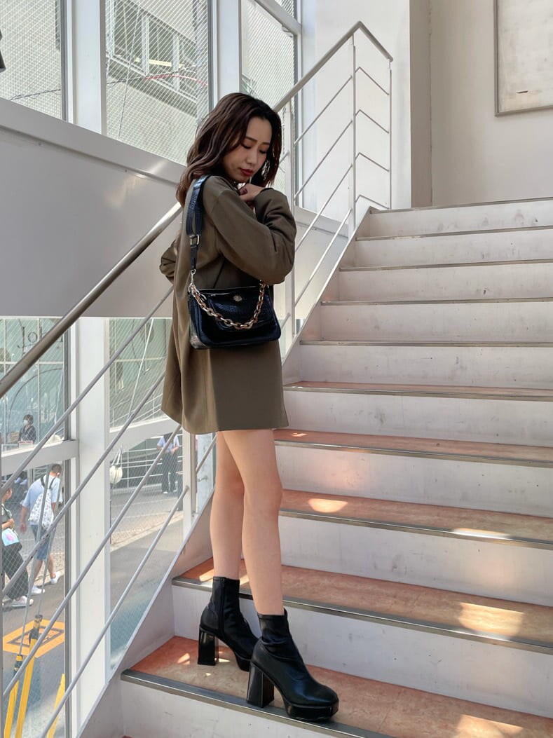 ベージュ系のテーラードジャケット、ブラック系のスカート、ブラック系のショルダーバッグを着用したレディースの秋コーディネートの4枚目の写真