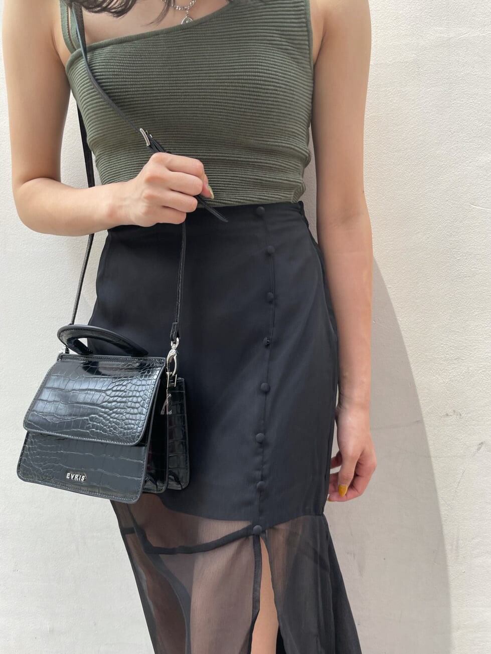 ブラック系のスカート、ブラック系のサンダル、ベージュ系のTシャツ/カットソーを着用したレディースの夏コーディネートの7枚目の写真