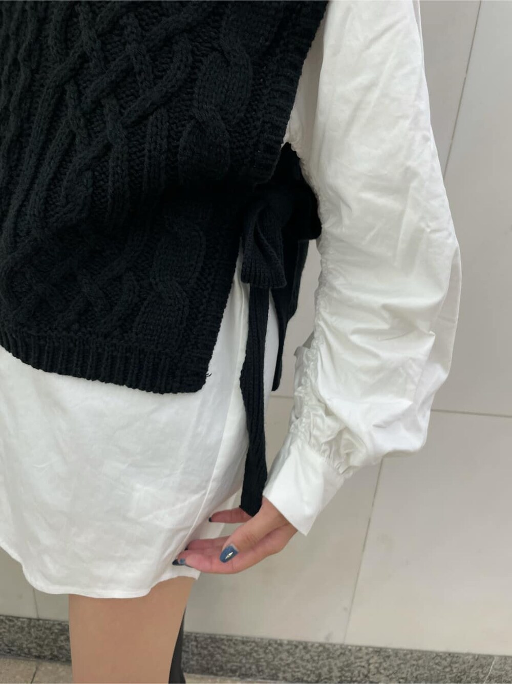 ブラック系のニット/セーター、ホワイト系のシャツ/ブラウス、ブラック系のショルダーバッグを着用したレディースの秋コーディネートの4枚目の写真