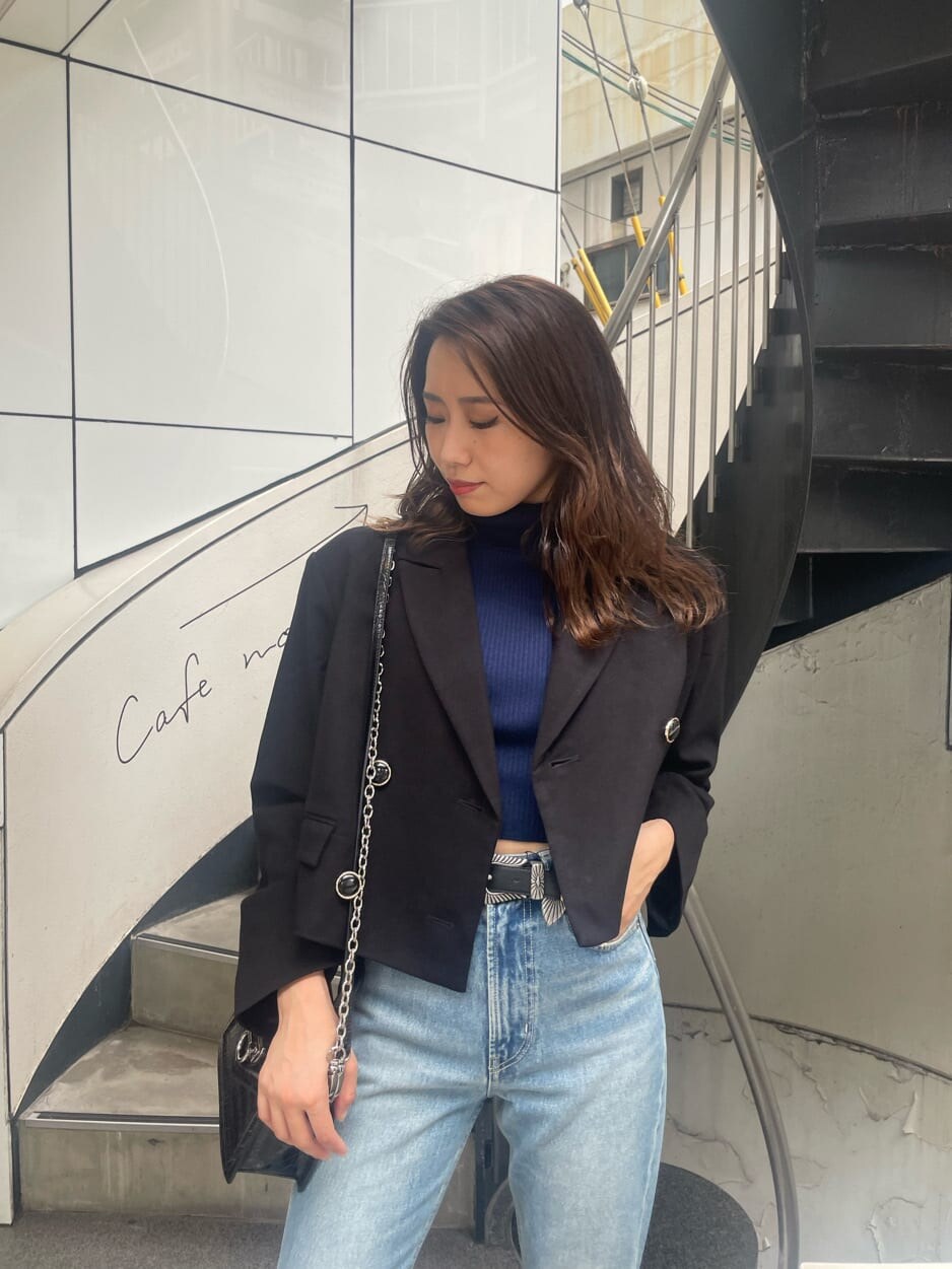 ブラック系のブーツ、ブラック系のテーラードジャケット、ブラック系のハンドバッグを着用したレディースの秋コーディネートの4枚目の写真