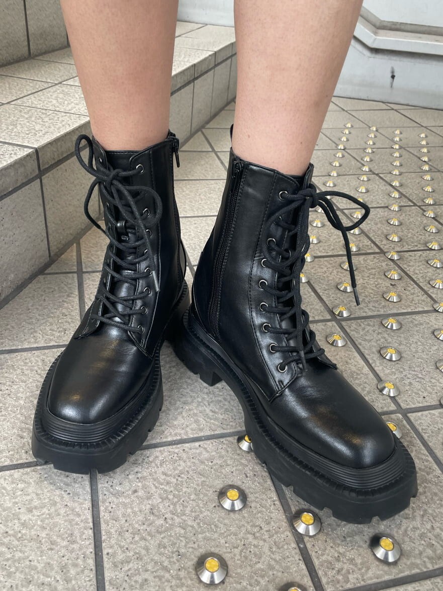 ホワイト系のテーラードジャケット、ブラック系のスカート、ブラック系のブーツを着用したレディースの冬コーディネートの10枚目の写真