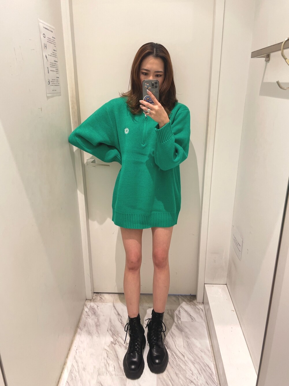 グリーン系のニット/セーター、ブラック系のブーツを着用したレディースの冬コーディネートの2枚目の写真