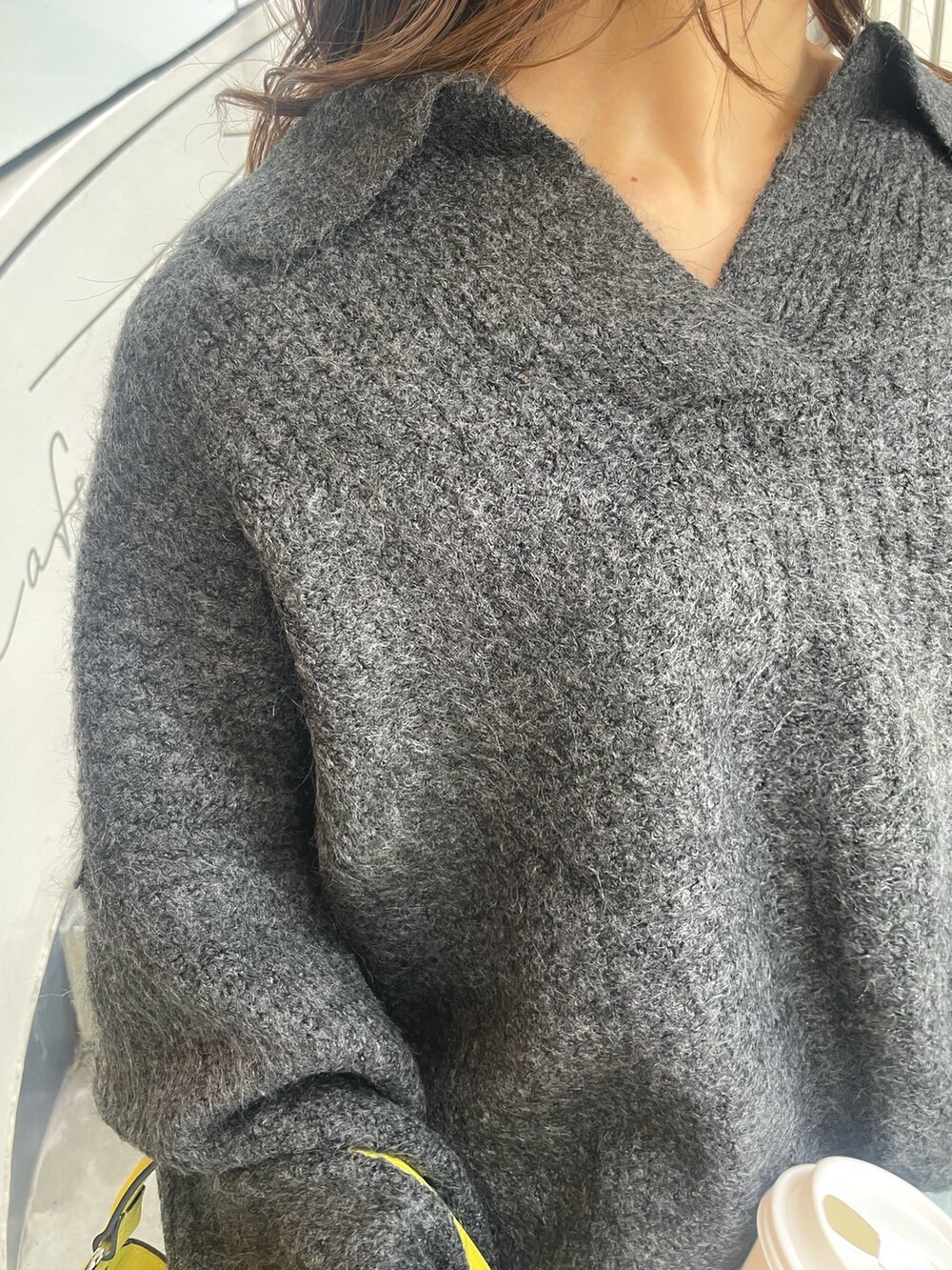 グレー系のニット/セーター、イエロー系のハンドバッグ、ブルー系のデニムパンツを着用したレディースの秋コーディネートの7枚目の写真