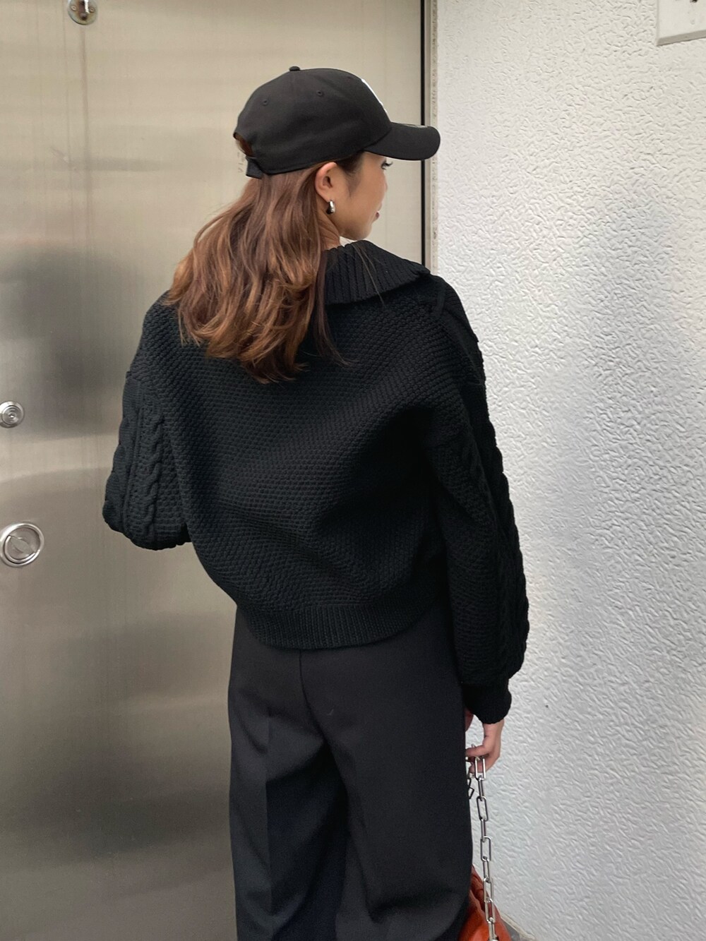 ブラック系のニット/セーター、ブラック系のスラックス、ブラック系のブーツを着用したレディースの冬コーディネートの7枚目の写真