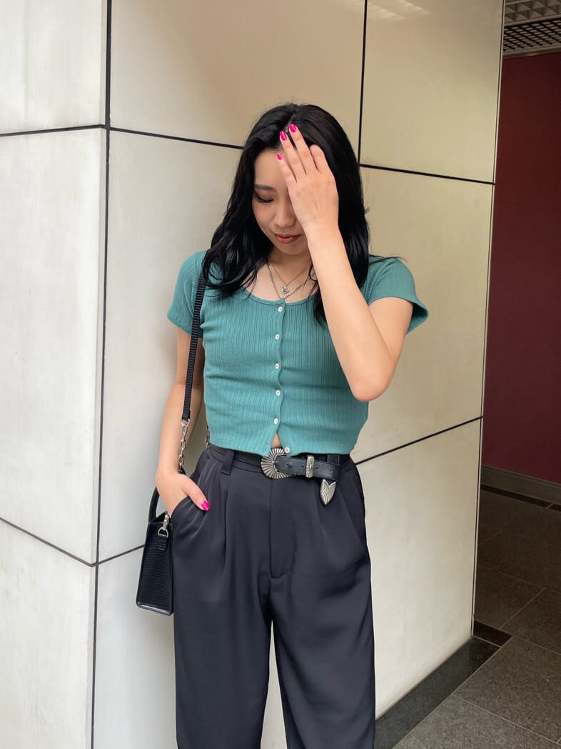 ブラック系のその他パンツ、グリーン系のTシャツ/カットソー、ブラック系のブーツを着用したレディースの春コーディネートの3枚目の写真