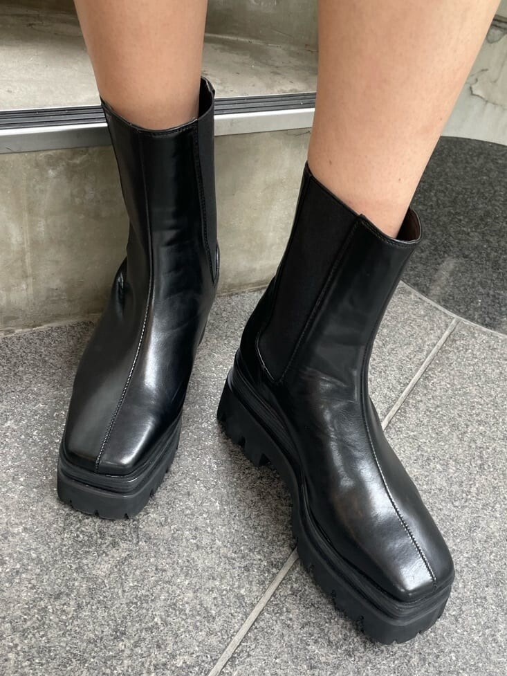 ベージュ系のトートバッグ、ブラック系のニット/セーター、ブラック系のブーツを着用したレディースの春コーディネートの7枚目の写真