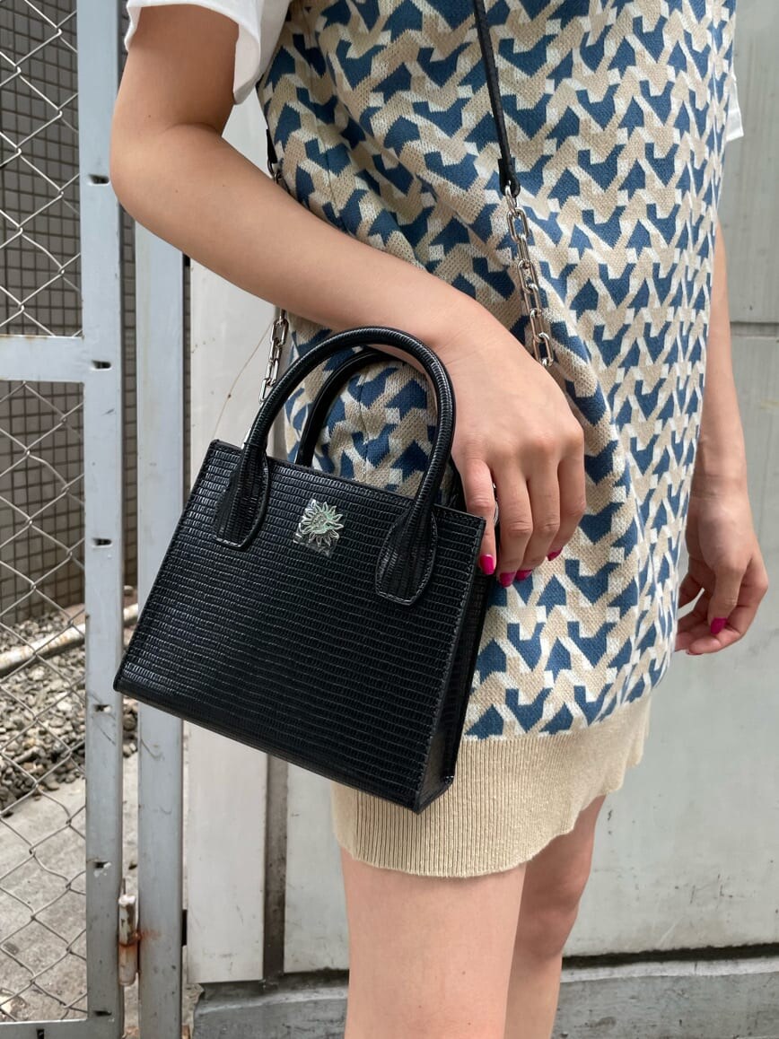 ブラック系のブーツ、ベージュ系のニット/セーター、ホワイト系のTシャツ/カットソーを着用したレディースの春コーディネートの7枚目の写真