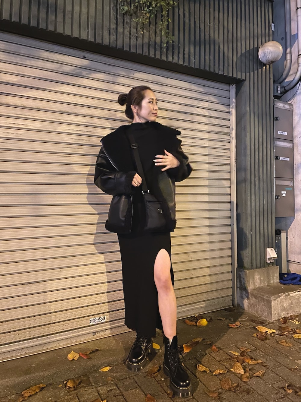 ブラック系のブルゾン、ブラック系のワンピース、ブラック系のブーツを着用したレディースの冬コーディネートの3枚目の写真