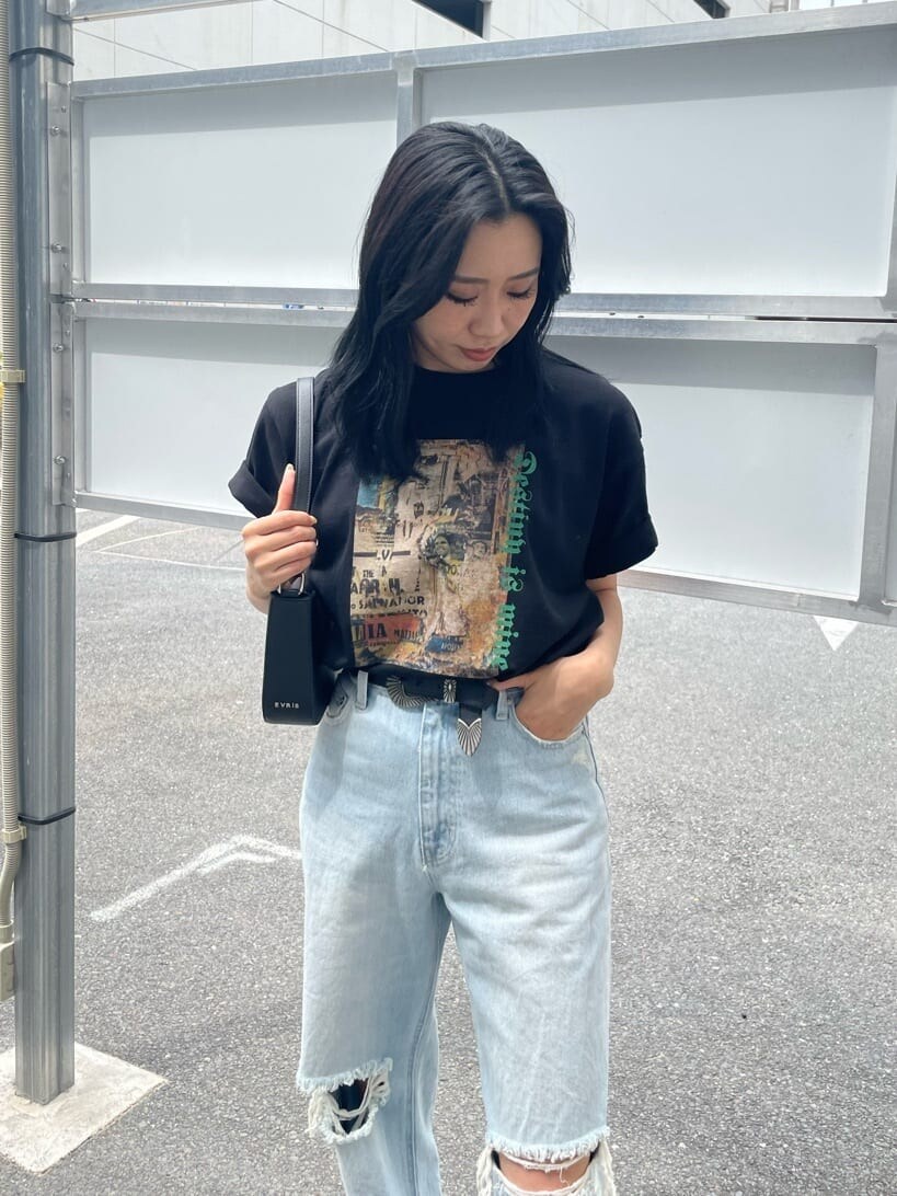 ブラック系のショルダーバッグ、ブルー系のデニムパンツ、ブラック系のTシャツ/カットソーを着用したレディースの夏コーディネートの3枚目の写真