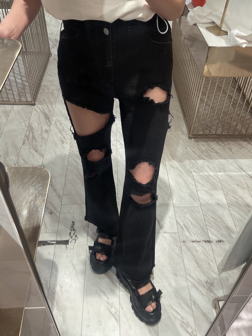 ブラック系のデニムパンツ、ブラック系のサンダル、ホワイト系のタンクトップを着用したレディースの春コーディネートの5枚目の写真