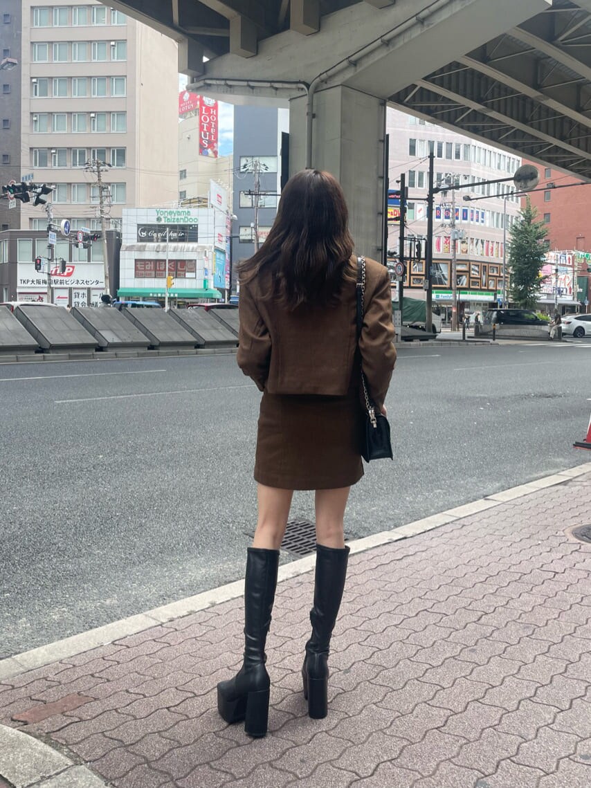 ブラック系のブーツ、ブラック系のTシャツ/カットソー、ブラウン系のテーラードジャケットを着用したレディースの秋コーディネートの3枚目の写真