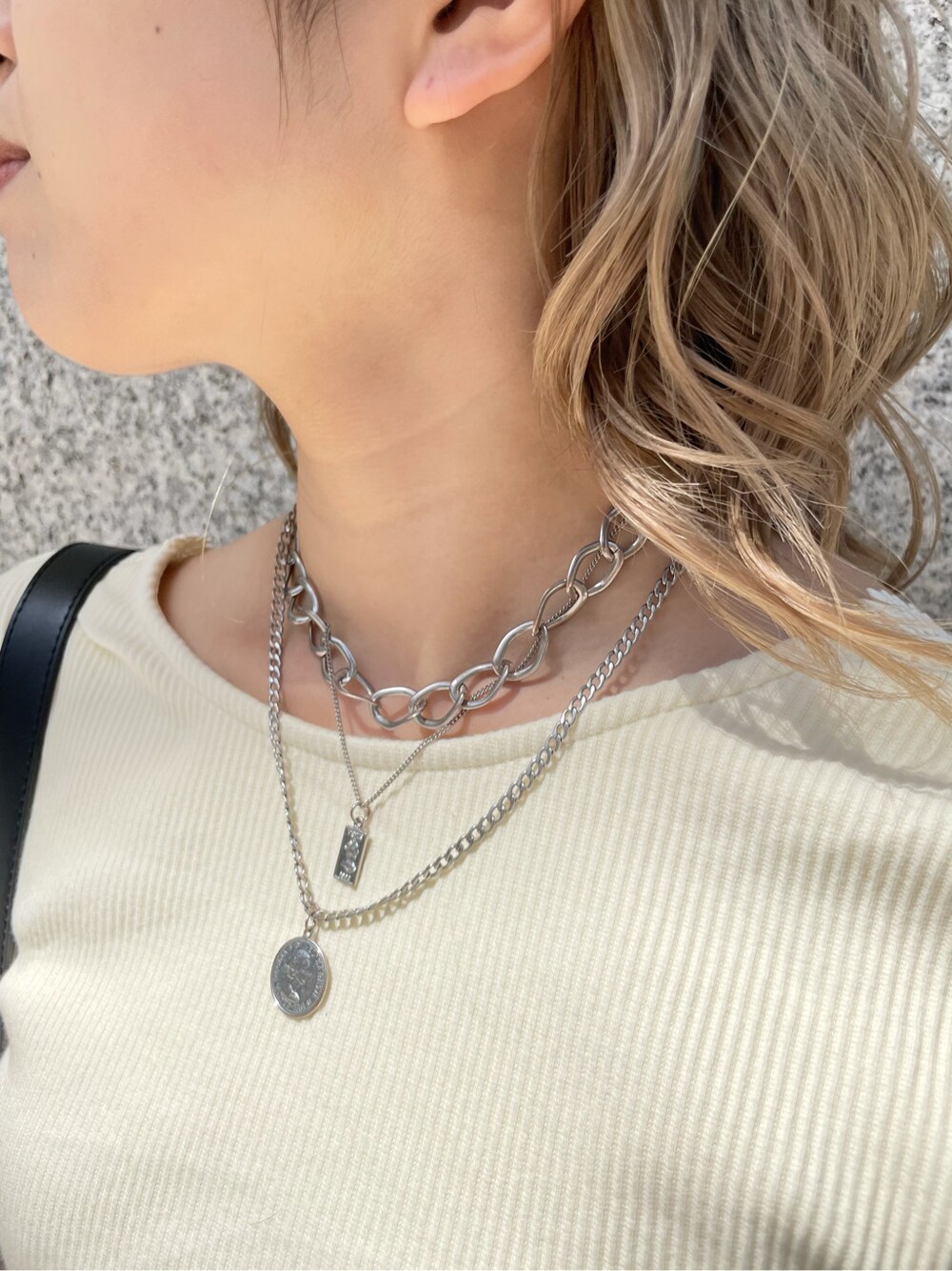 ブラック系のショルダーバッグ、ベージュ系のデニムパンツ、ホワイト系のTシャツ/カットソーを着用したレディースの春コーディネートの6枚目の写真