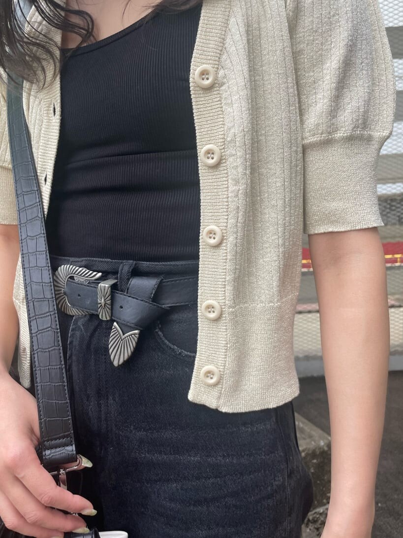 ブラック系のデニムパンツ、ブラック系のキャミソール、ホワイト系のカーディガン/ボレロを着用したレディースの春コーディネートの8枚目の写真