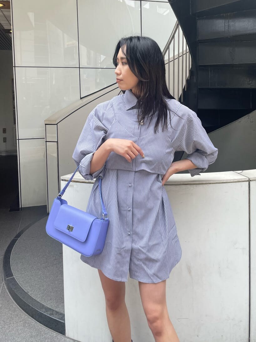 ブラック系のブーツ、ブラック系のワンピース、パープル系のショルダーバッグを着用したレディースの春コーディネートの4枚目の写真