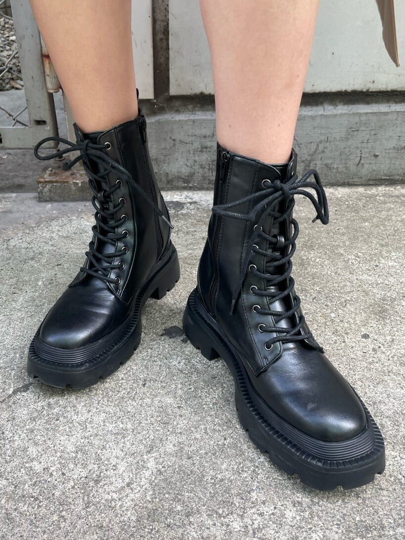 ブラック系のブーツ、ベージュ系のトレンチコート、ブラック系のショルダーバッグを着用したレディースの春コーディネートの8枚目の写真