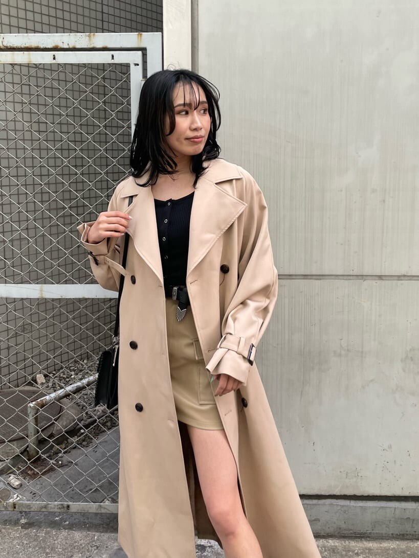 ベージュ系のスカート、ブラック系のブーツ、ベージュ系のトレンチコートを着用したレディースの春コーディネートの3枚目の写真